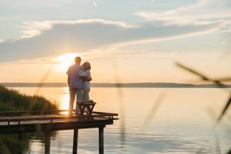 retired couple watching the sunset over the water